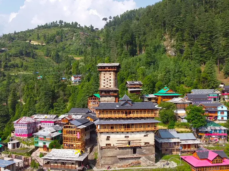 Chaini Kothi Jibhi ancient wooden tower against the mountains